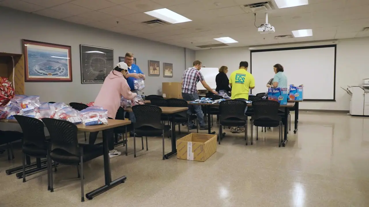 People around tables packing ziploc bags of snacks.