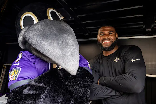 Ravens mascot and player in the back of the Weekend Backpacks cargo van