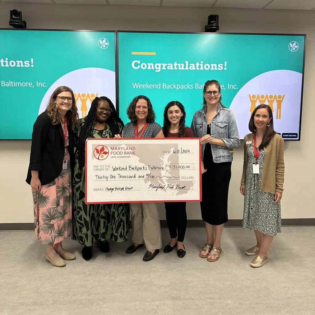 Six women holding a large check from the Maryland Food Back to Weekend Backpacks.