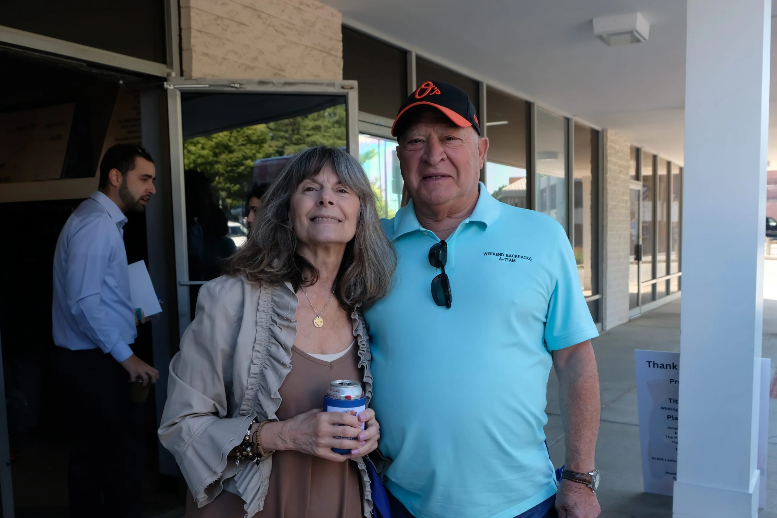 Two people standing outside smiling.