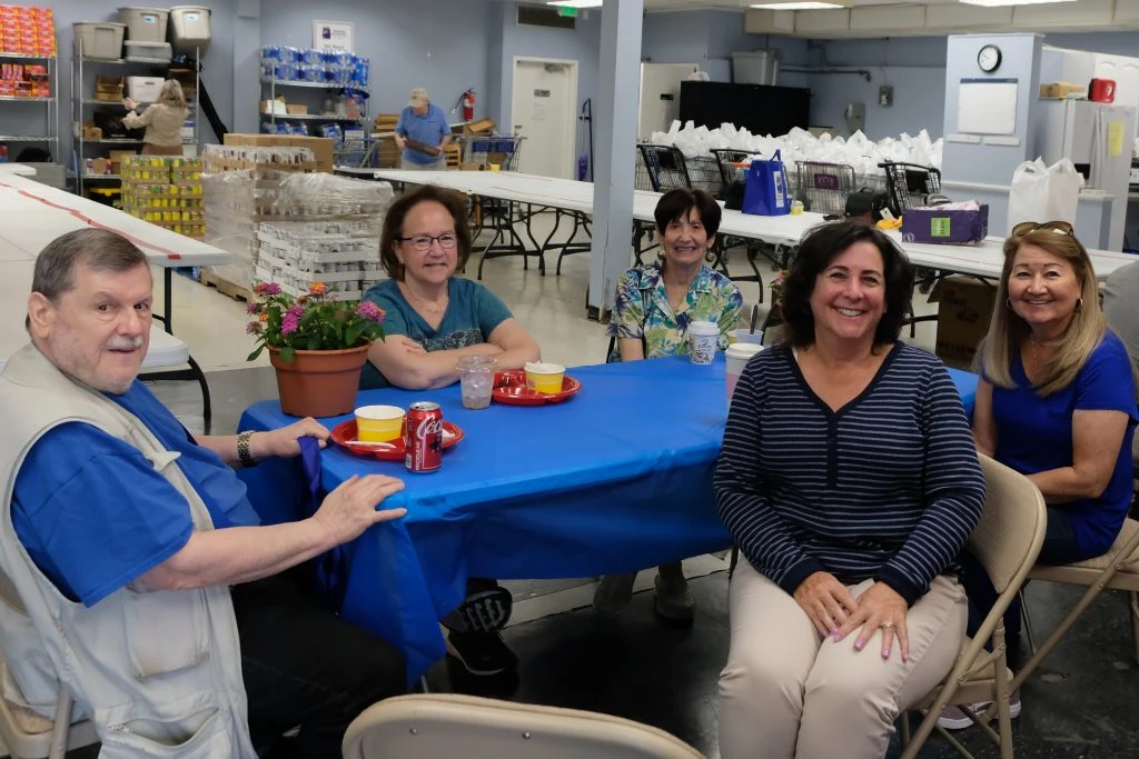 A group of people sitting at a table smiling.