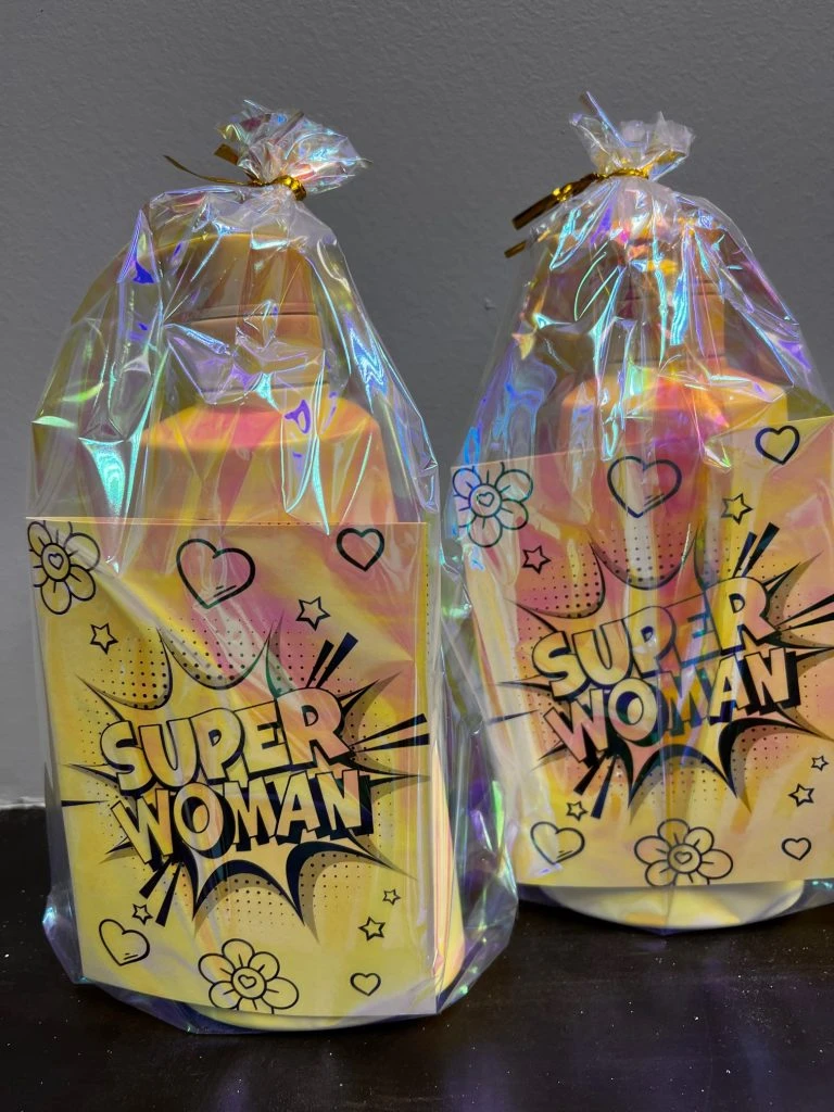 A bottle of lotion and a card reading "Super Woman" in a gift bag.