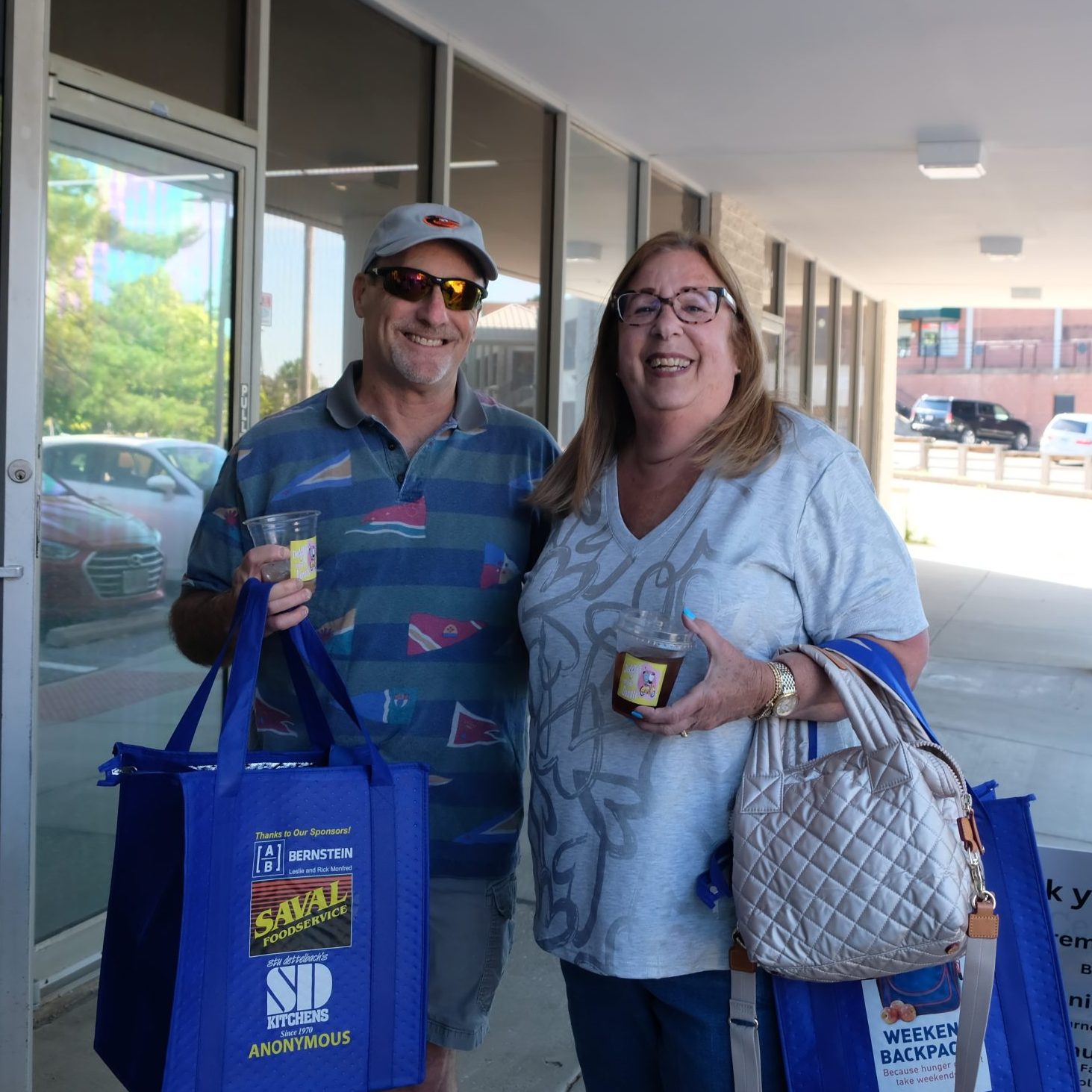 Two people smiling outside of Weekend Backpack's facility.