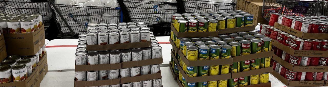 A table with piles of cases of cans.