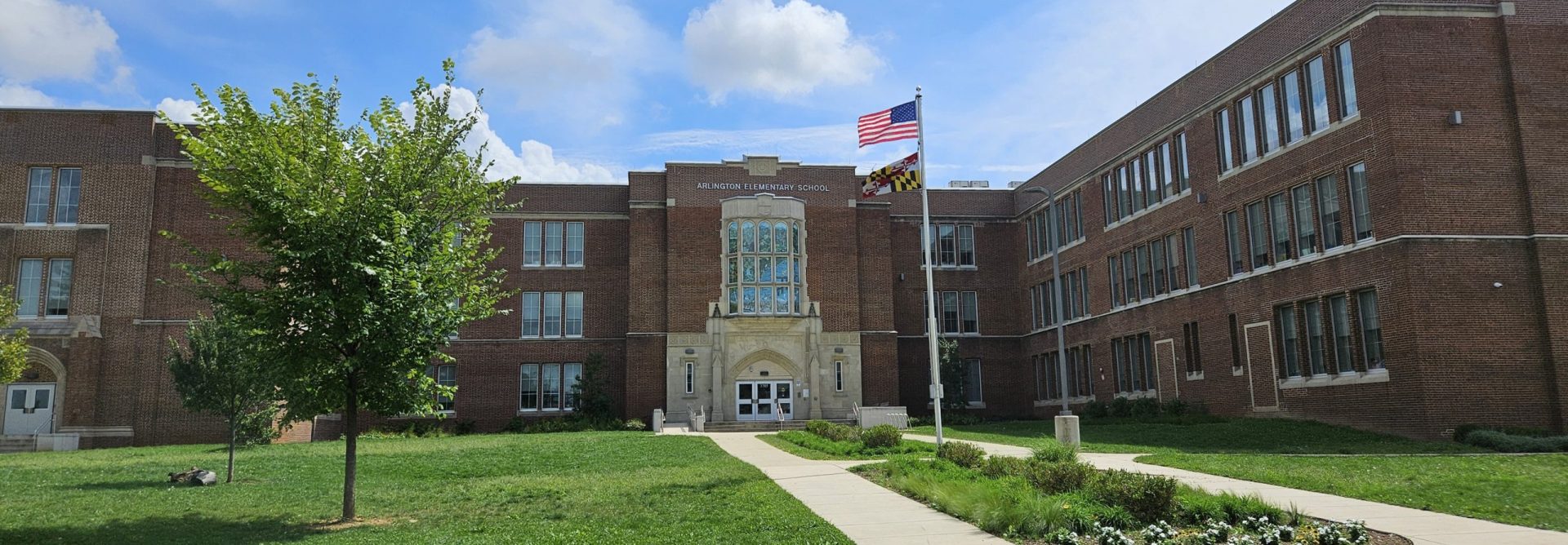 The outside of a school with a sign saying 